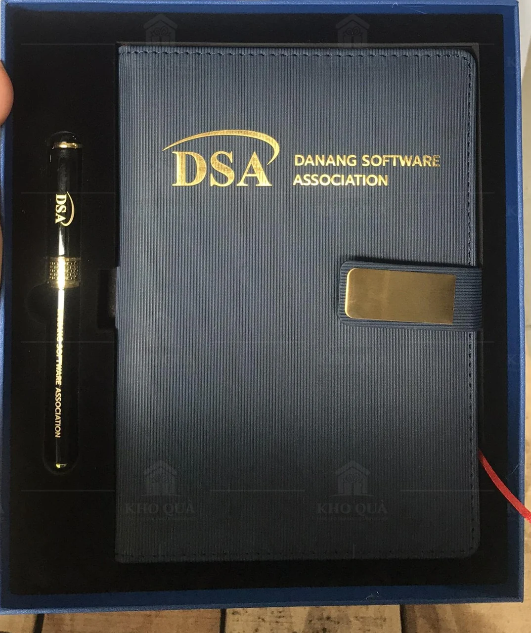Sổ và bút in DSA đặt trong khay hộp xanh