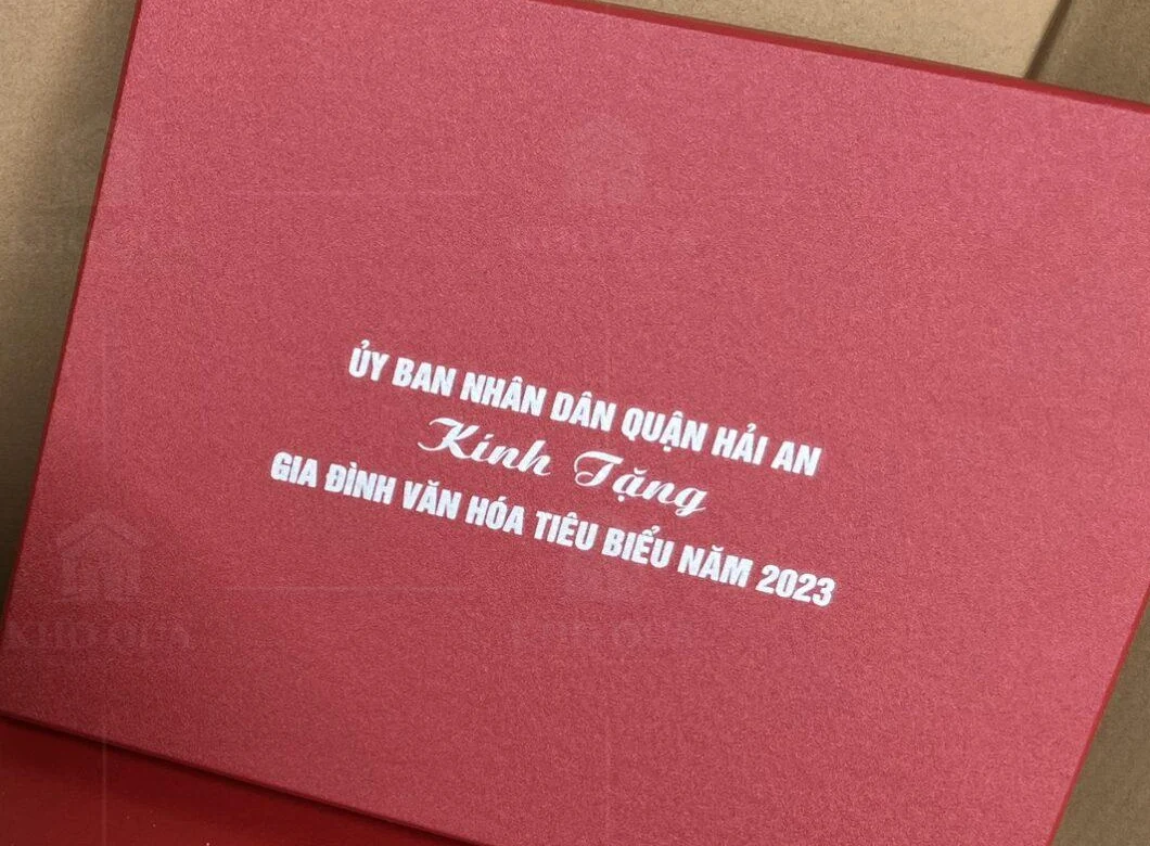 Nắp hộp đỏ có tên đơn vị, lời kính tặng và năm
