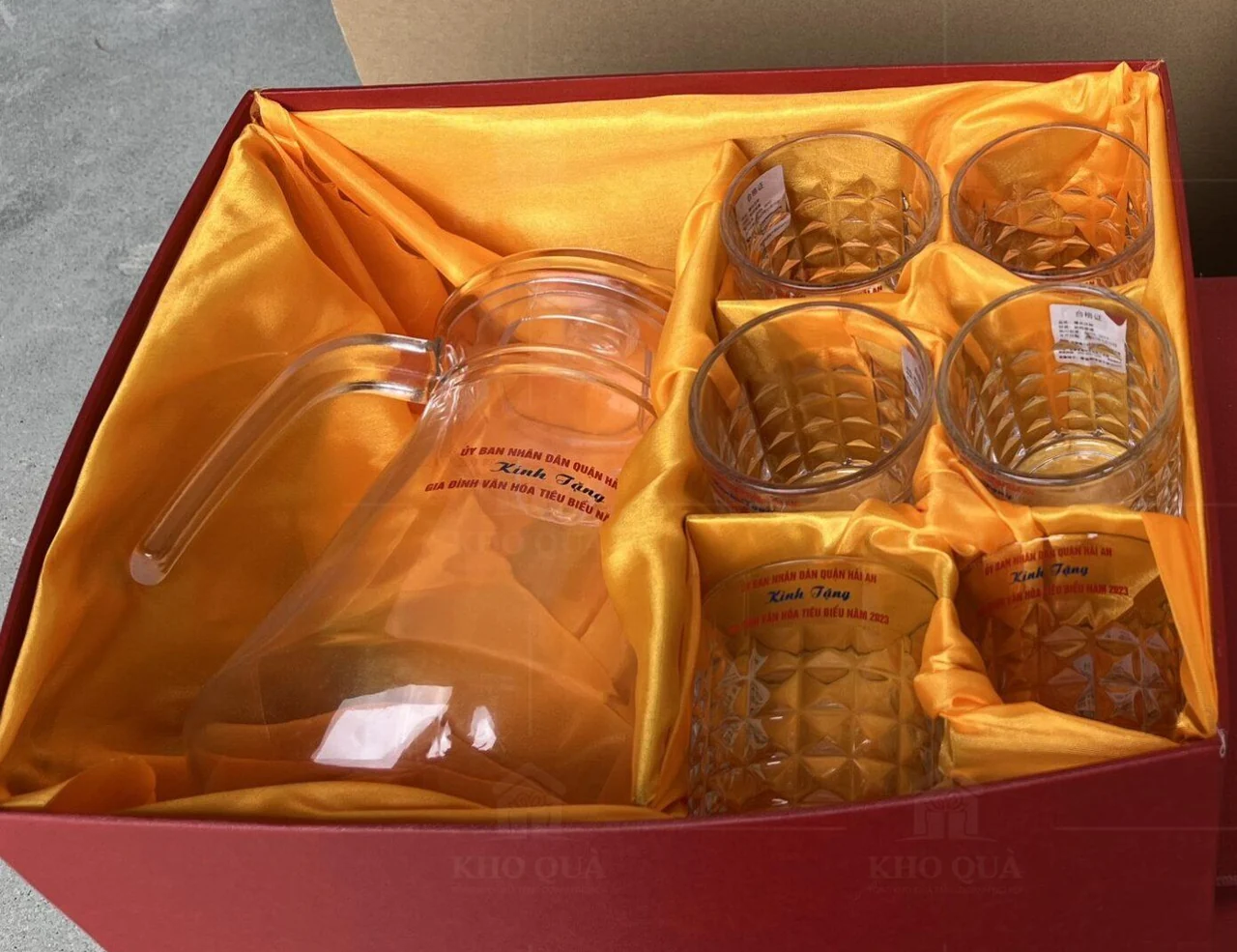 Bình và sáu cốc trong các vùng riêng của hộp đỏ lót vàng