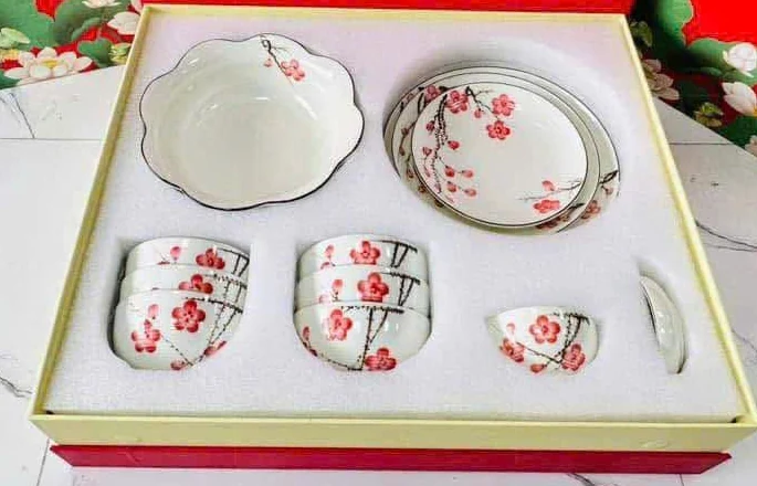 Bát và đĩa hoa đỏ xếp trong khay hộp