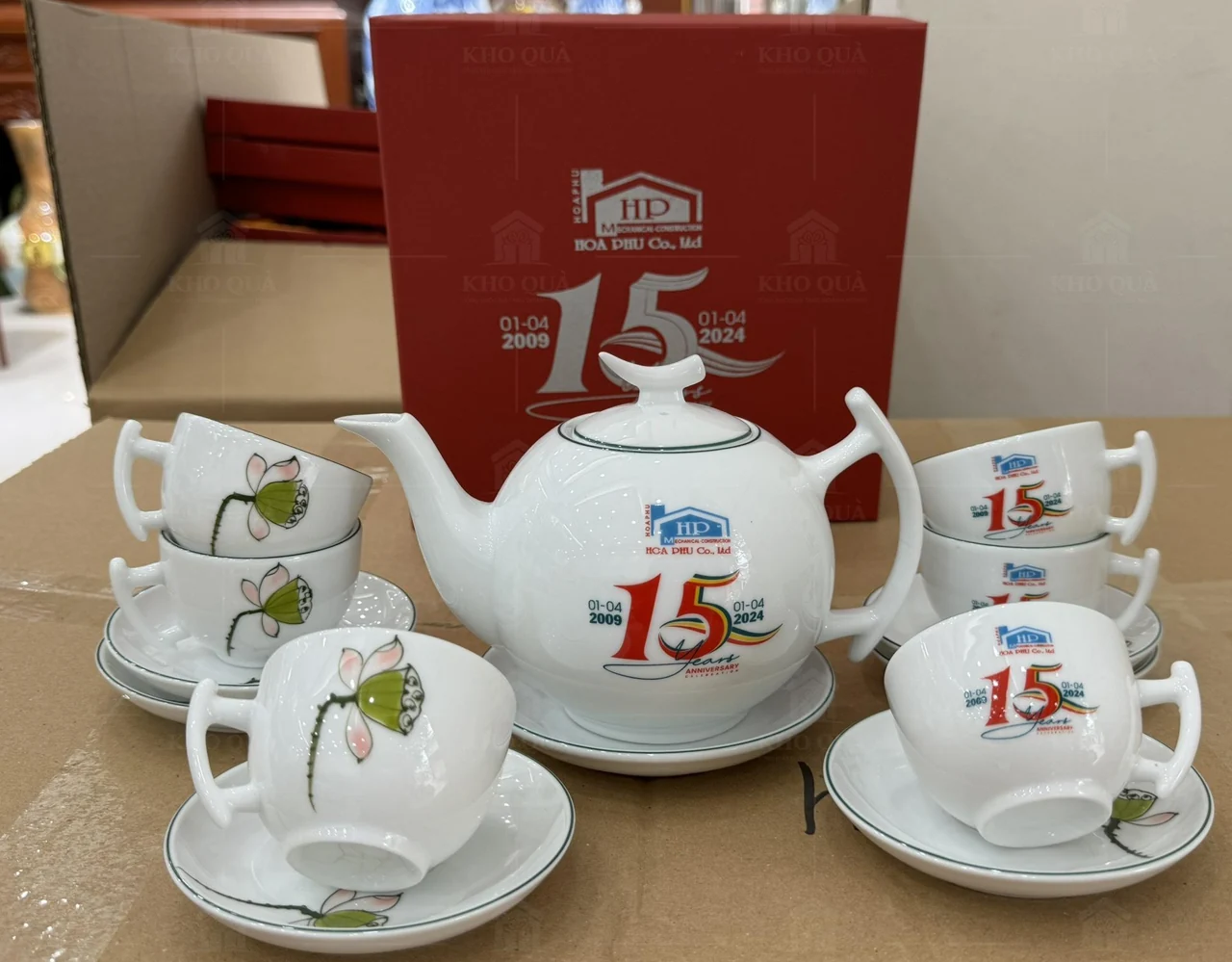 Bộ trà hoa sen in nội dung kỷ niệm cạnh hộp quà đỏ đóng