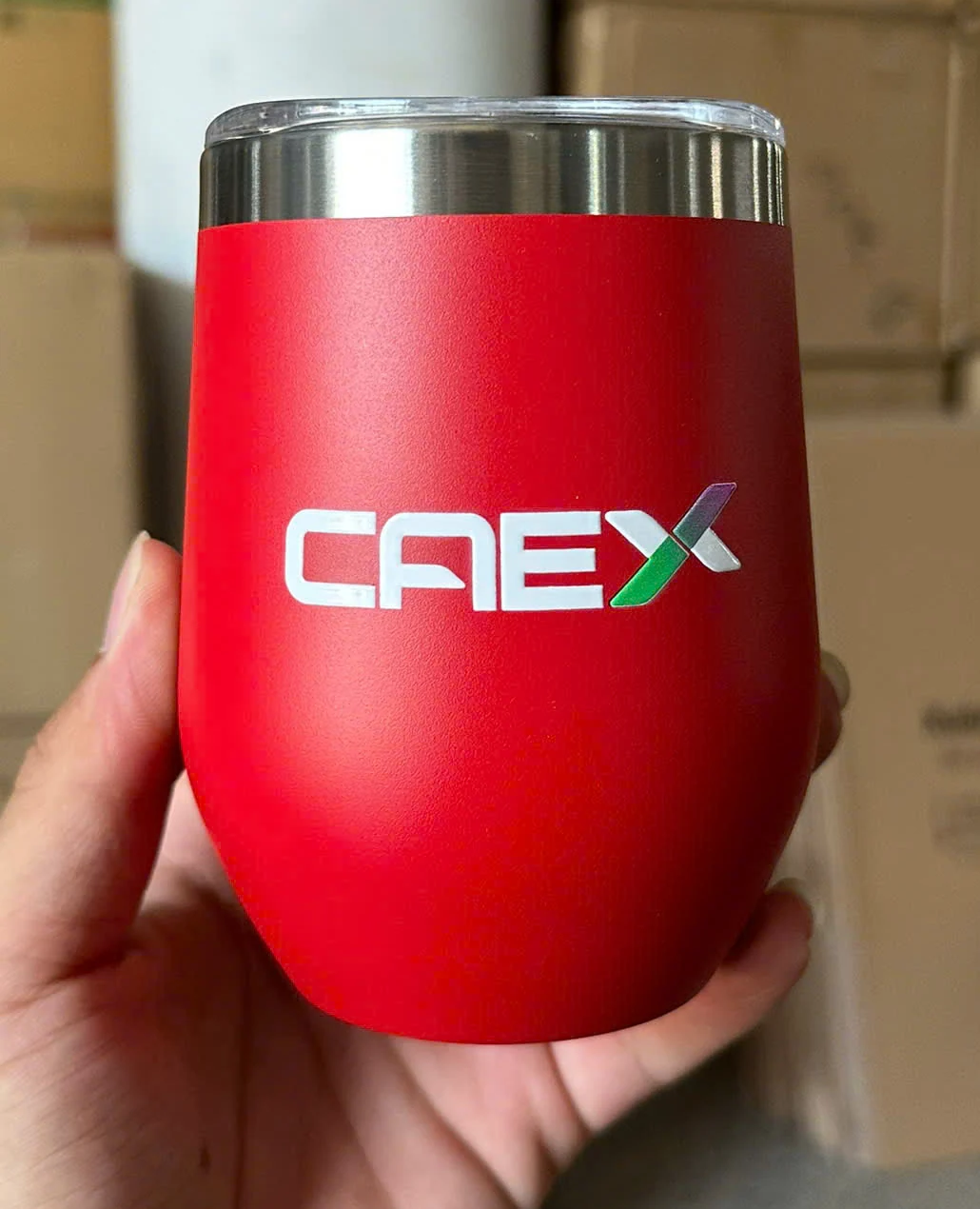 Ly đỏ cầm trên tay có logo in trên thân
