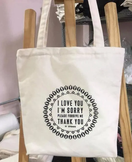 Túi canvas trắng quai dài và nội dung in tròn trên mặt chính