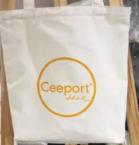 Góc mặt túi trắng có đường may miệng và logo Ceeport màu vàng
