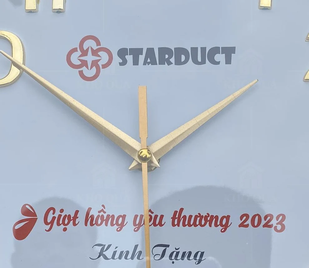 Góc logo Starduct, tâm kim và lời tặng trên đồng hồ tròn gỗ