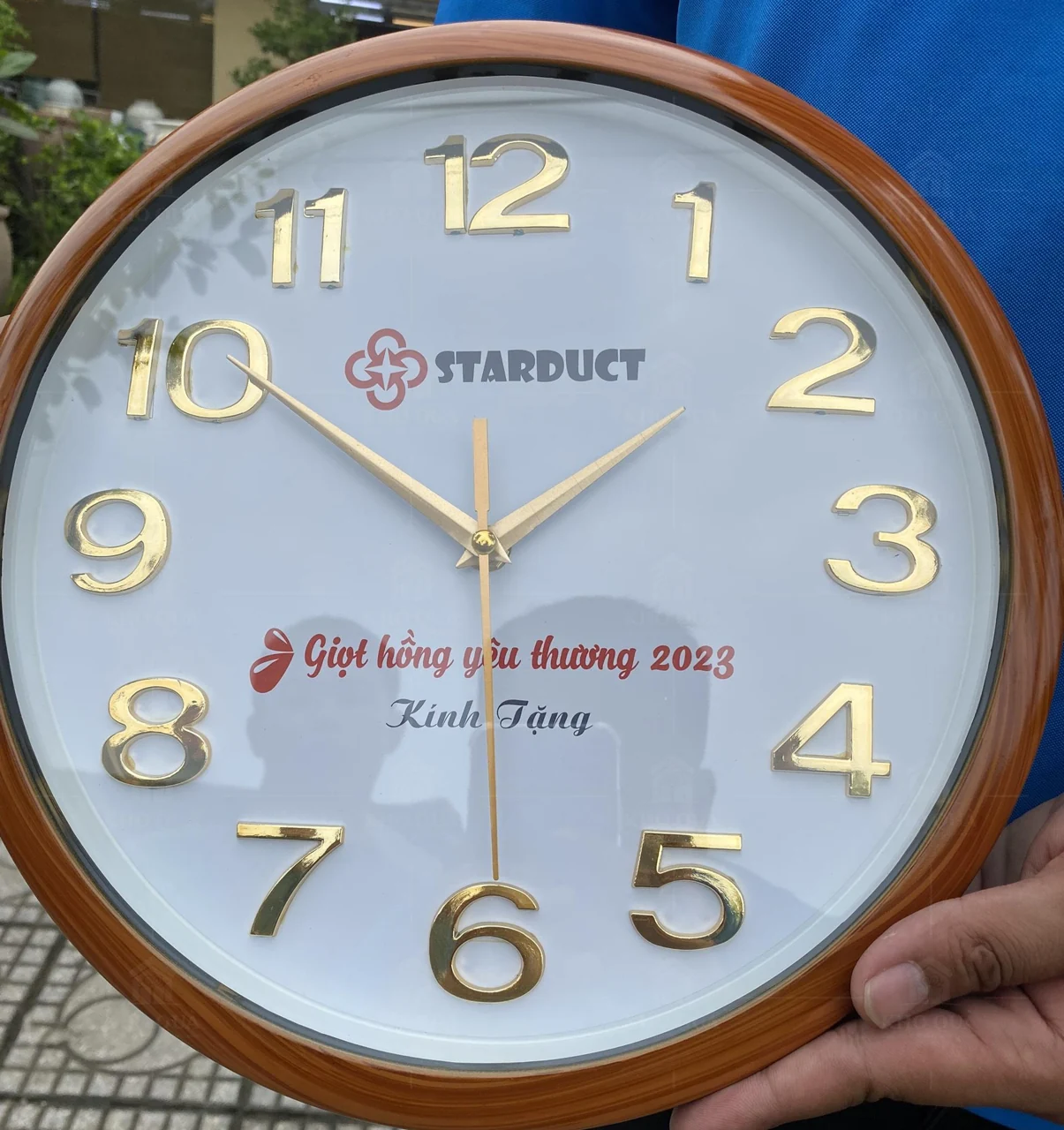 Đồng hồ tròn gỗ có logo Starduct và lời tặng năm 2023