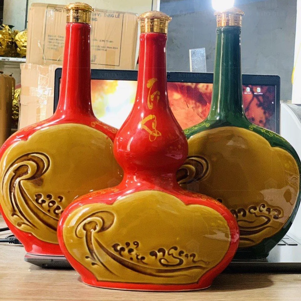 Các chai cổ dài, thân rộng men đỏ và xanh với mặt trang trí vàng trong gallery 1L–01
