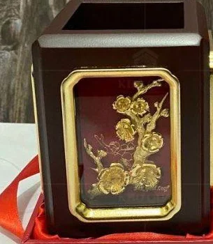 Cận mặt đỏ, họa tiết thực vật và viền vàng trên ống bút