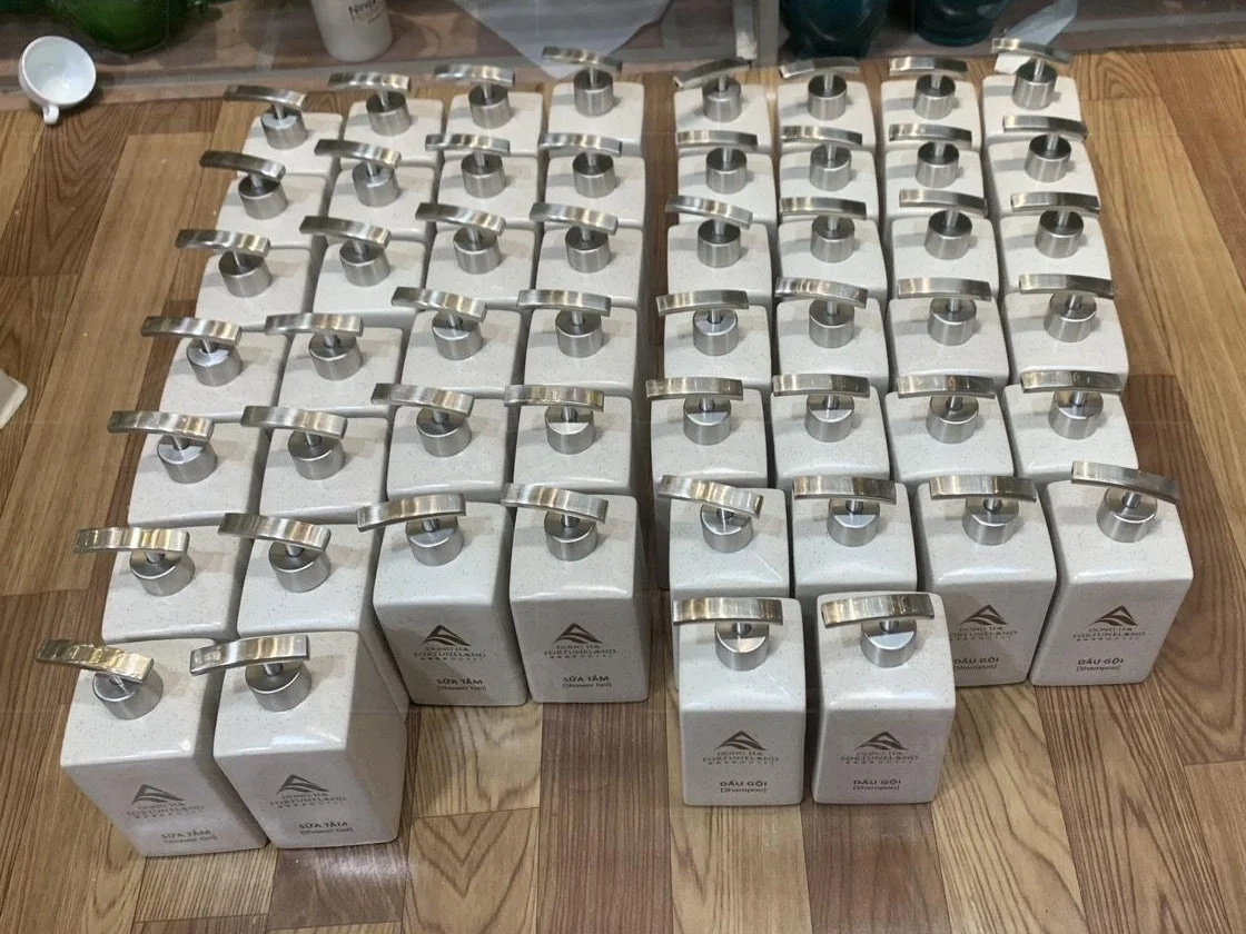 Các bình vuông có nhãn dầu gội và sữa tắm xếp thành nhóm trong gallery
