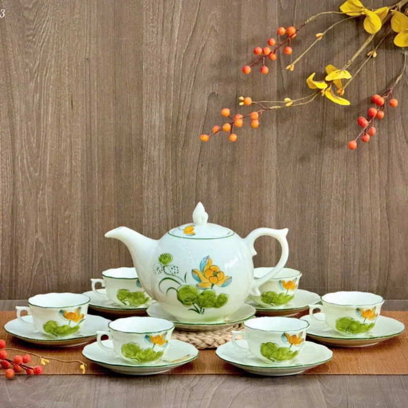 Bộ trà màu men sáng vẽ hoa sen vàng xanh trên nền gỗ