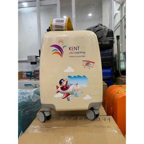 Vali màu kem in nhận diện KENT và máy bay đặt trên kiện trong kho