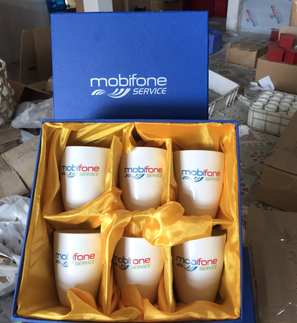Hộp xanh có sáu cốc in mobifone SERVICE trong các ô lót