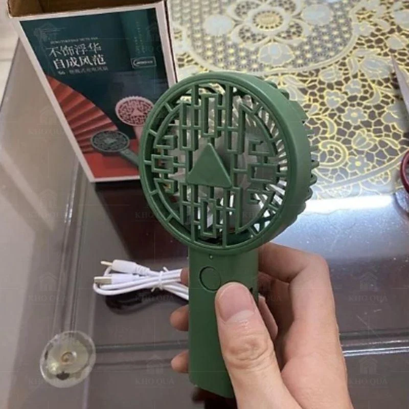Mẫu quạt xanh có nút tròn dưới lồng đang được cầm