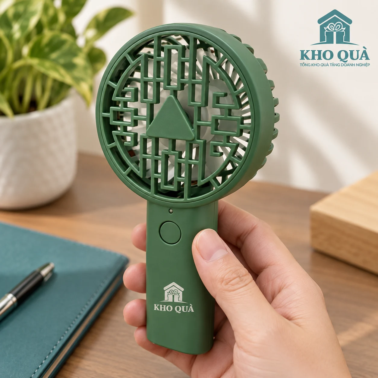 Phương án cầm quạt xanh lồng hình học có logo KhoQua dưới nút