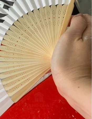 Góc cận vùng tay cầm và phần nan hoa văn của quạt xếp