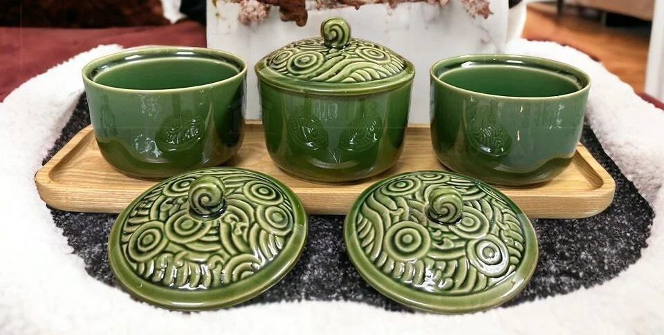 Ba hũ xanh trên khay, một nắp đóng và hai nắp đặt phía trước