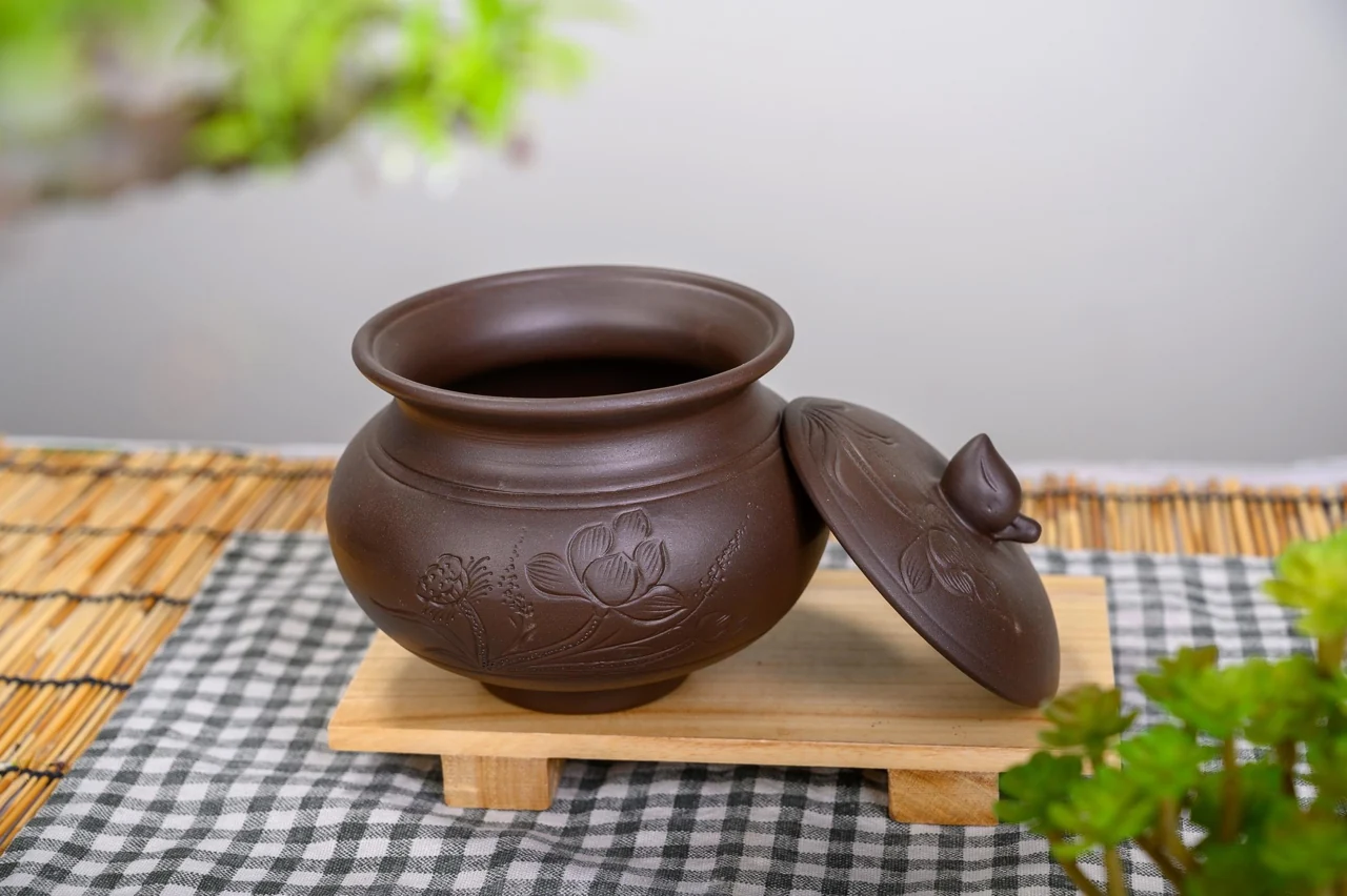 Hũ tròn nâu mở cùng nắp hoa sen đặt cạnh trong kho chung