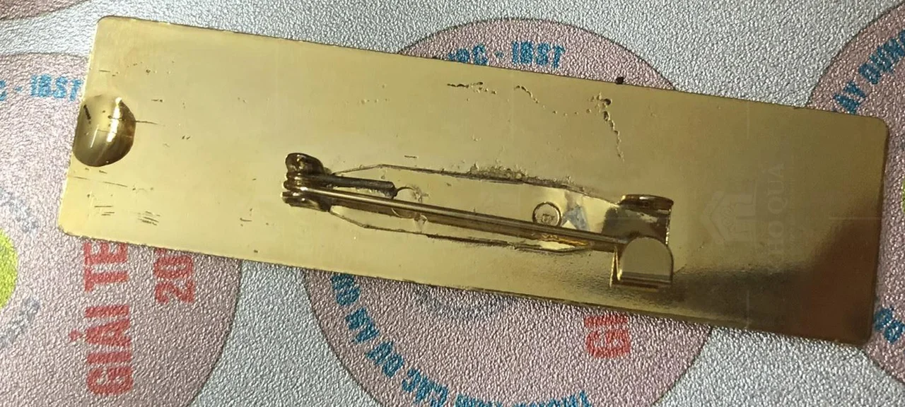 Mặt sau thẻ tên chữ nhật có ghim dài và đầu giữ